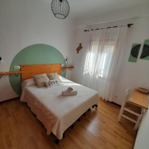 格拉纳达Casa Cervantes的一间卧室配有一张大床和绿色床头板