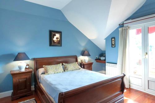 PiedrahitaDuplex Playa Berria的一间卧室配有一张蓝色墙壁的床