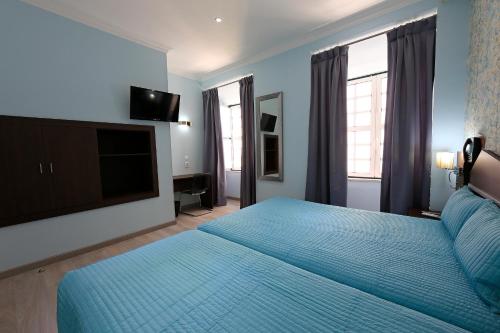 里斯本菲盖拉广场公寓的一间卧室配有蓝色的床和一台平面电视