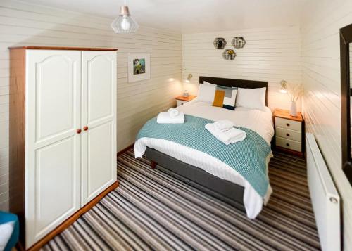 StrattonIvyleaf Combe Lodges的一间卧室配有带毛巾的床