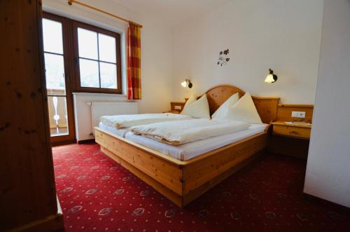 魏森湖豪斯黑曼特酒店的一间卧室设有一张木床和一个大窗户。