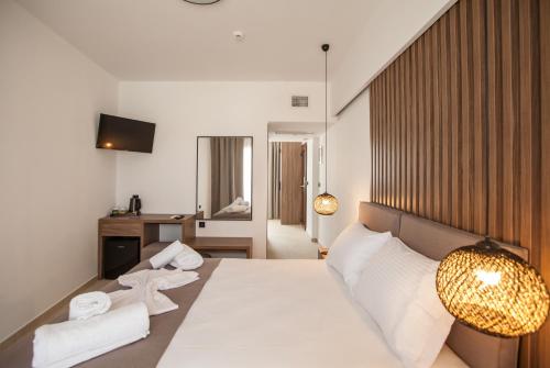 阿菲托斯Verano Afytos Hotel的一间卧室配有带白色床单和毛巾的床。