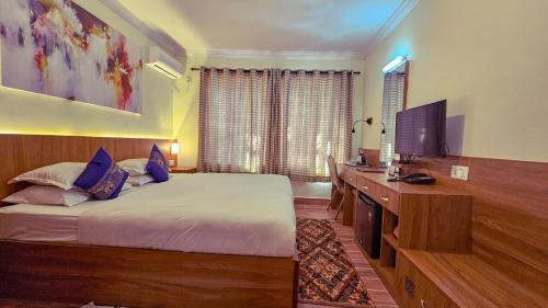 加德满都Chef House Resort的一间卧室配有一张床和一台平面电视