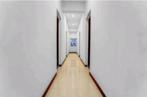 哥印拜陀Hotel Crown Tower的走廊设有白色墙壁和木地板