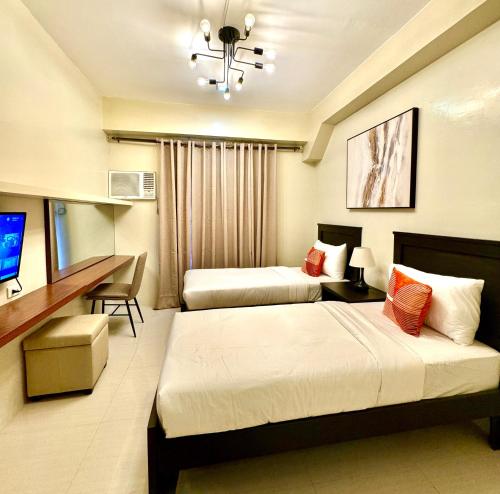 马尼拉G Square Residences的酒店客房配有两张床和一张书桌