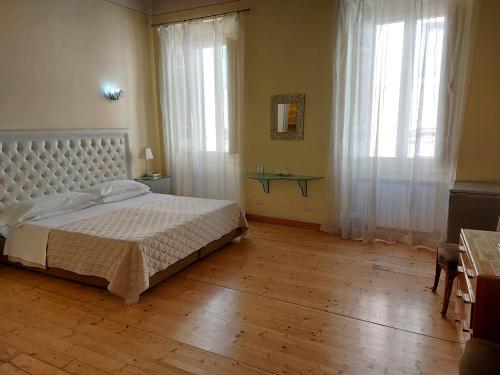 罗马Residenza Al Corso Suites的卧室配有白色的床,铺有木地板