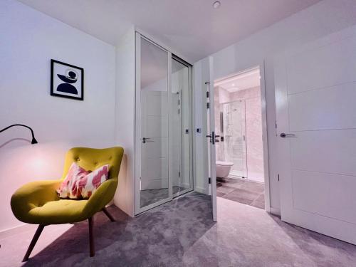 伦敦NEW Cosy 3BR Apartment With Private Garden In Olympic Park的浴室设有黄色椅子和镜子