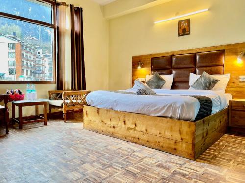 马拉里The Kalinga Resort Manali - Heaven In Mountains的一间卧室设有一张大床和一个大窗户