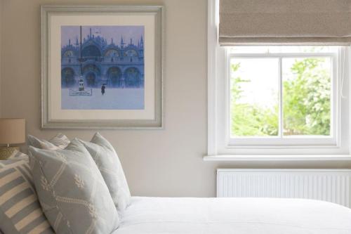 科尔切斯特Stylish and homely 1 bed Edwardian Coach House的白色的卧室设有床和窗户