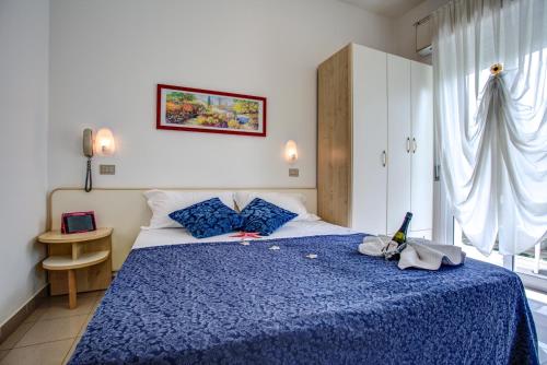 里米尼提兹亚娜酒店的一间卧室配有蓝色的床和蓝色的毯子
