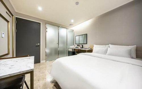 首尔Mnlucky Hotel的一张大白色的床,位于酒店客房内