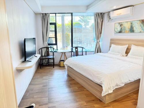 珠海Zhuhai Dreamers Capsule Hotel的一间卧室配有一张床、一台电视和一张桌子