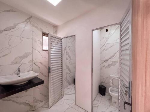 孔芬斯Sítio com Piscina e Hidromassagem Confins的白色的浴室设有水槽和卫生间。