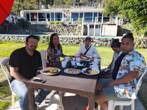 圣佩德罗拉拉古纳Hotel Porto Bello的一群坐在桌子旁吃食物的人