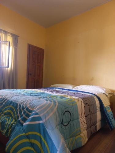 明多Casa de Albert的一间卧室配有一张带彩色毯子的床