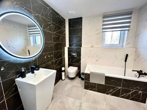 捷克利帕Apartmány PREMIUM se soukromým parkováním的一间带水槽、浴缸和镜子的浴室