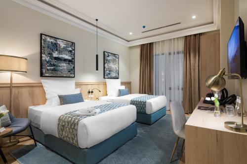 吉达Marlo Hotel的酒店客房配有两张床和一张书桌