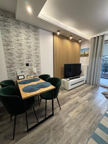 奥斯特罗达Apartament Kamila Ostróda的客厅配有桌椅和电视。