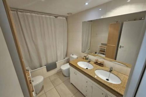 巴达洛纳Apartamento completo con piscina terraza vistas del mar的浴室设有2个水槽、卫生间和镜子。