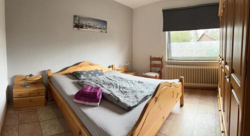 VinstedtFerienwohnung am Eschenberg的一间卧室设有一张木床和一个窗户。