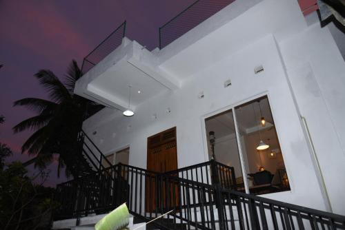 康提Everdew Kandy的白色的房子,有楼梯和棕榈树
