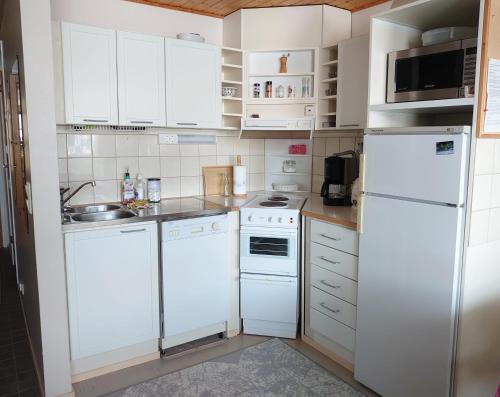 塔库沃里Rivitalon lomahuoneisto Tahkolla的厨房配有白色家电和白色橱柜