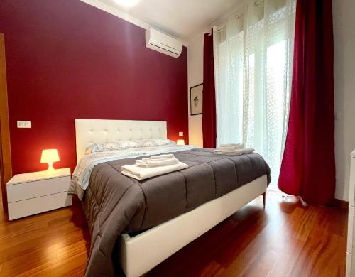 罗马Lucens Domus Appartamento Roma quartiere Trieste - vicino Metro b1 -的一间卧室设有一张带红色墙壁的大床