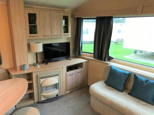 纽基Newquay Bay Porth Caravan - 8 Berth的一个带电视和沙发的大篷车客厅