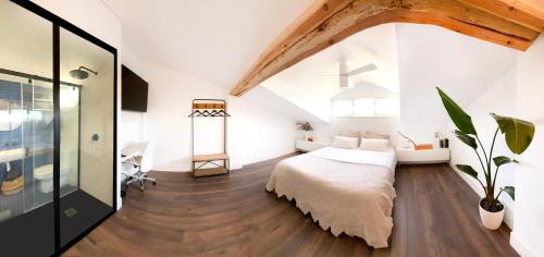 维多利亚-加斯特伊兹Luxury Pintoreria Atico的一间卧室设有一张大床,铺有木地板