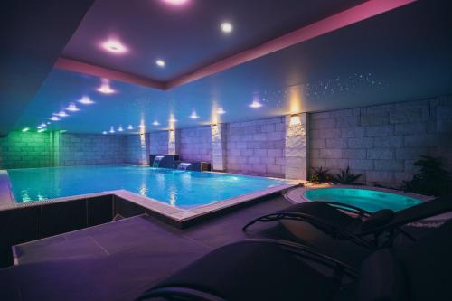 巴尼亚卢卡Wellness Spa Hotel Jola的一座大型游泳池,位于一座拥有温水的建筑中