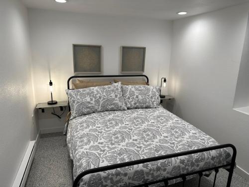 夏延Basement Bliss: Cozy Getaway的一间卧室配有一张床和一张带两盏灯的桌子。