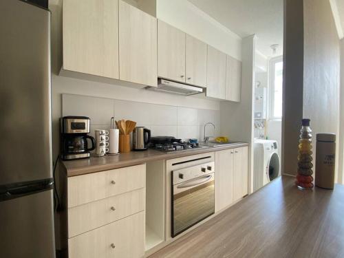 蒙特港Depto nuevo con estacionamiento的厨房配有白色橱柜和炉灶烤箱。