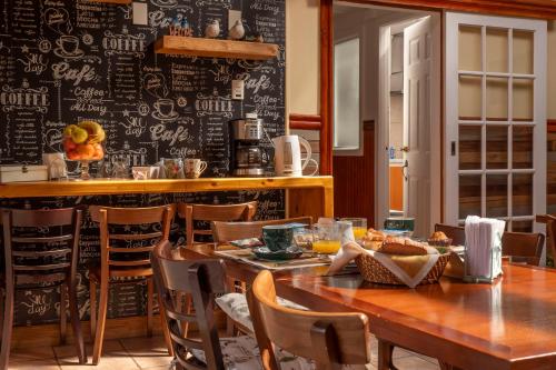 蓬塔阿雷纳斯Hotel Albatros的一间设有桌子和粉笔板墙的用餐室