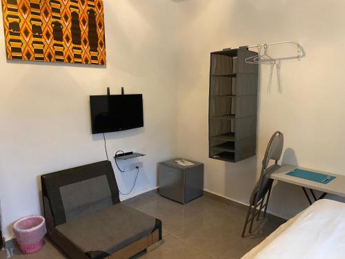 弗里敦Belvoir Apart-Hotel & Residence的客房设有1张床、1台电视和1张桌子。