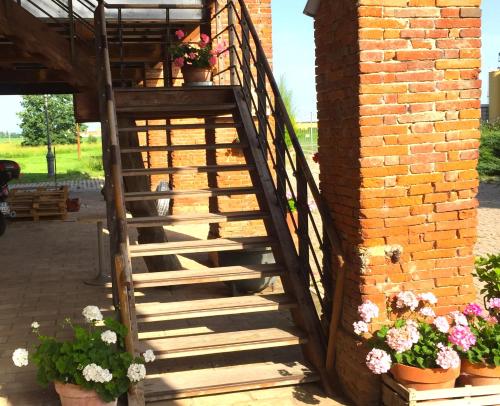 MontechiarugoloRustic Parma Retreat的砖墙旁的木楼梯,花朵