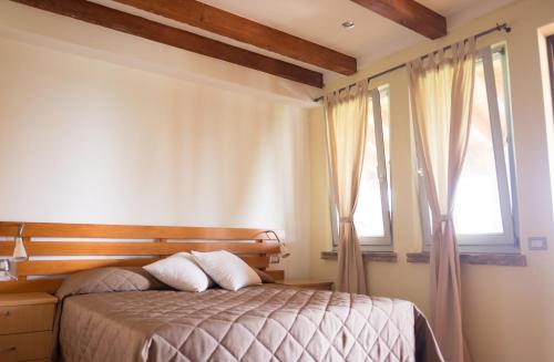 MontechiarugoloRustic Parma Retreat的一间卧室设有一张床和两个窗户。