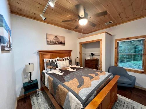 布赖森城Nantahala Nook, cabin w/hot tub,game room, & wifi的一间卧室配有一张床和一把椅子