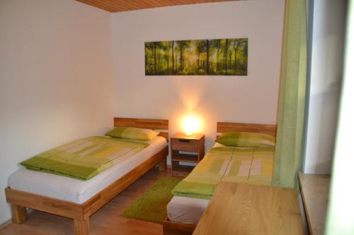 GeorgensgmündFerienwohnung Vera的一间卧室配有两张床和一张带台灯的桌子