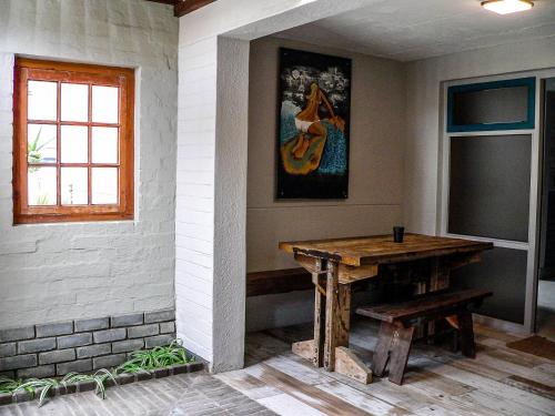 鲸湾港de Baken Self-Catering的一间设有木桌和壁画的房间