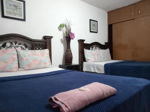 危地马拉Historico maya的一间带两张床的卧室和鲜花花瓶