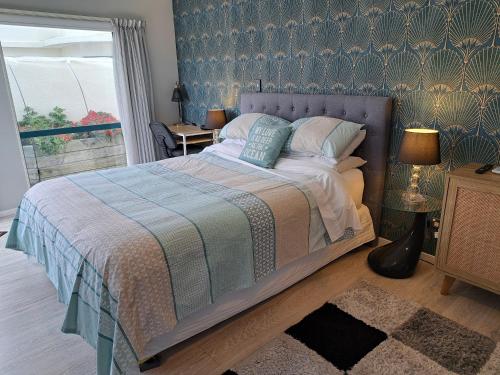 芒格努伊山Sunbrae Beach Sanctuary free high Fibre wifi的一间卧室配有一张带蓝色图案墙壁的床