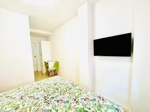 阿雷纳斯德圣佩德罗Hostal La Taberna的一间卧室配有一张床,墙上配有电视