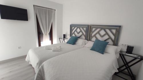 Calera de LeónCASA RURAL ELENYR的卧室配有带蓝色枕头的大型白色床