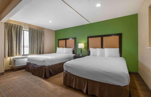 弗洛伦斯Extended Stay America Select Suites - Cincinnati - Florence - Meijer Dr的绿墙旅馆客房的两张床