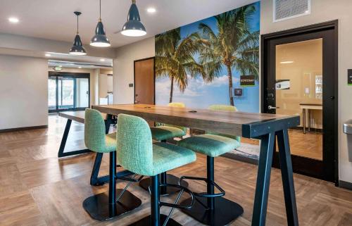 坦帕Extended Stay America Premier Suites - Tampa - Fairgrounds - Casino的用餐室配有带绿椅的大型木桌