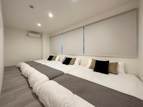 ŌsukachōbHOTEL Nikke - Apt for 10Ppl Ideal for Big Group in City Center的客房内的3张大型白色床