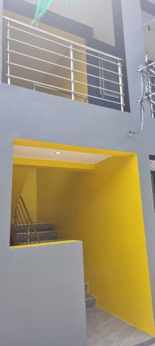 苏瓦ZEG的一间设有黄色和白色墙壁和楼梯的客房