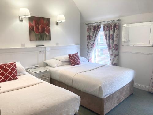 都柏林德格瓦罗酒店的一间卧室设有两张床和一个带红色郁金香的窗户。