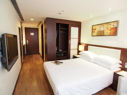 香港218 Apartment的卧室配有白色的床和平面电视。