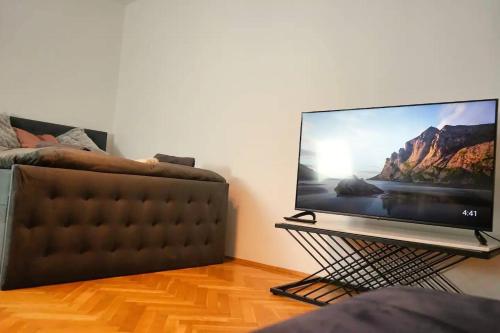 维也纳City Nook Apartments Near Hauptbahnhof的沙发旁的立柱上配有平面电视